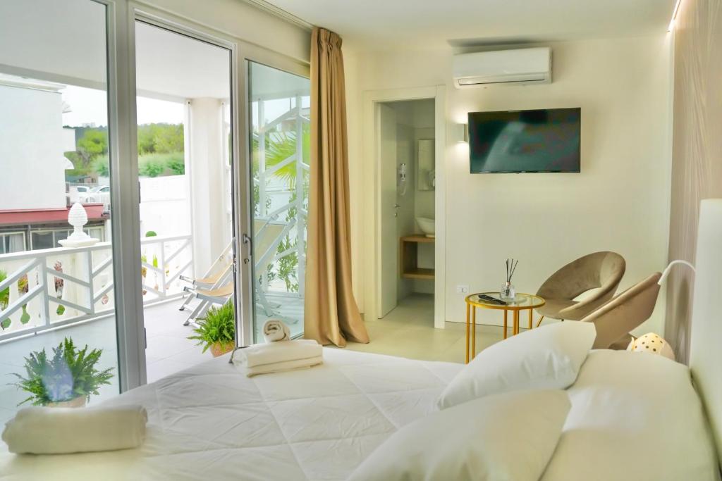 una camera con un grande letto bianco e un balcone di Sirena Suite Deluxe a Peschici