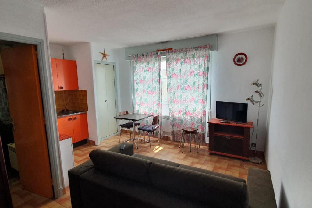 ein Wohnzimmer mit einem Sofa und einem Tisch in der Unterkunft Charming accommodation on the Port of Gruissan in Gruissan