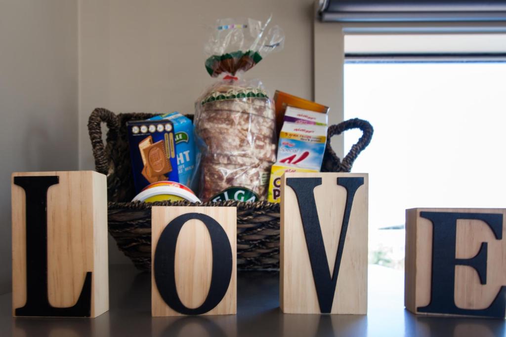 um cesto de comida e um sinal que diz amor em Silversands Beach Cottage em Mount Martha