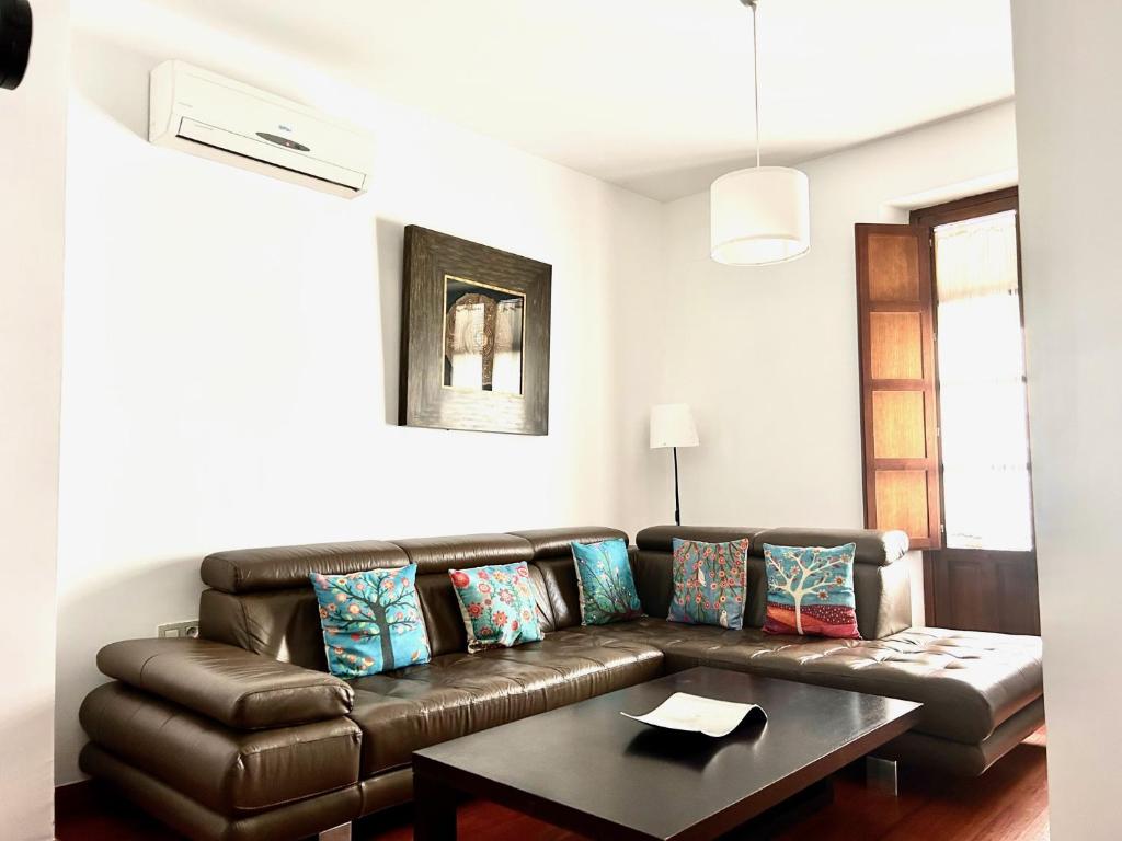 uma sala de estar com um sofá de couro castanho e uma mesa em Hispalis San Julian em Sevilha