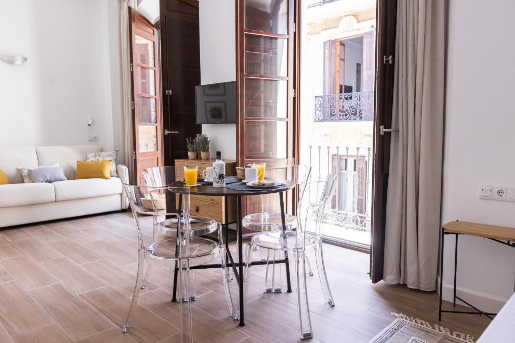 ein Wohnzimmer mit Tisch und Stühlen und einer Couch in der Unterkunft Apartamento-Loft Especería Black in Málaga