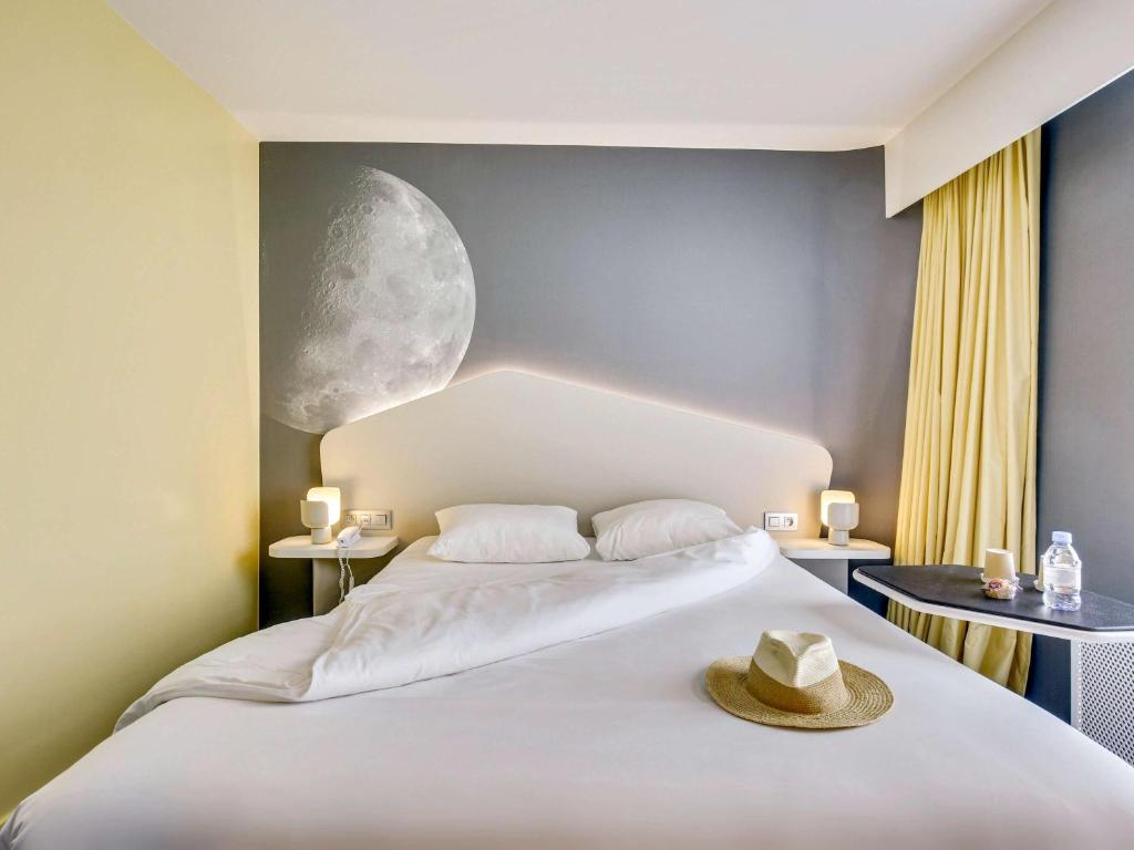 a bedroom with a bed with a hat on it at ibis Styles Paris Charles de Gaulle Airport in Roissy-en-France