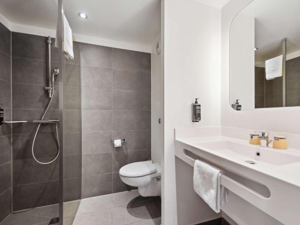 a bathroom with a toilet and a sink and a shower at ibis Styles Paris Charles de Gaulle Airport in Roissy-en-France