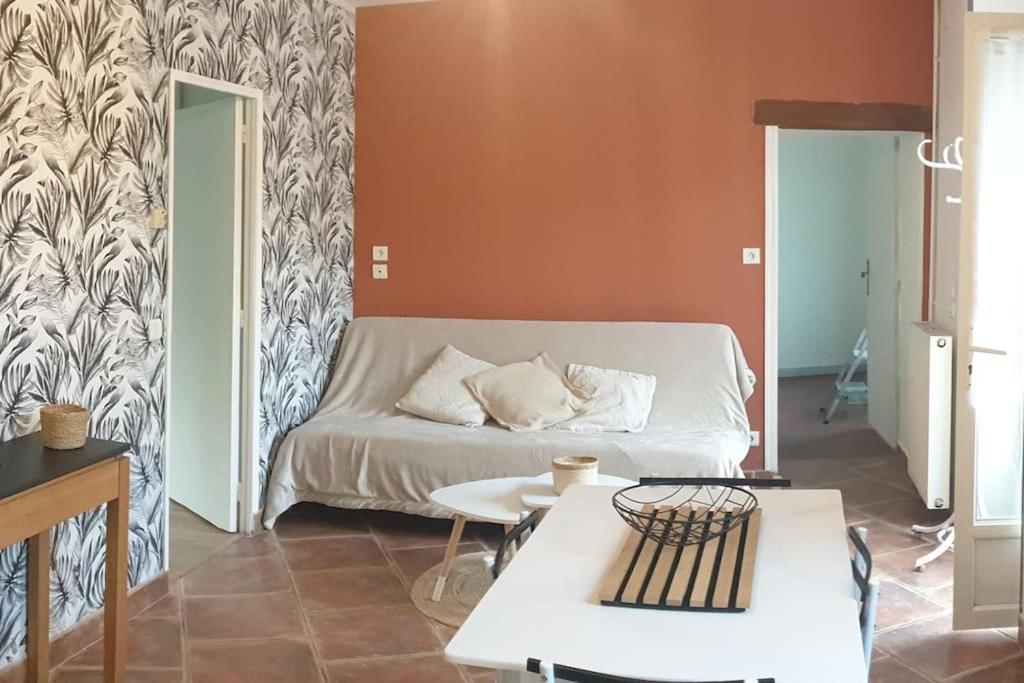 a living room with a bed and a table at Bienvenue chez nous in Guérigny
