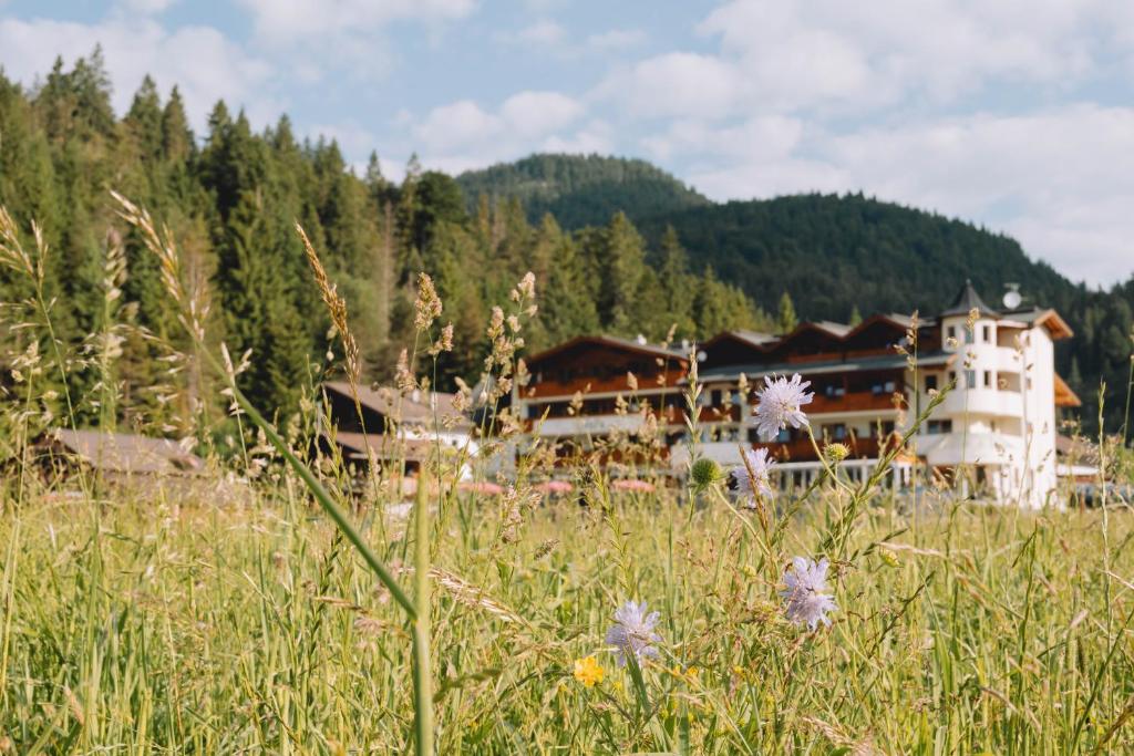 un grande edificio in mezzo a un campo con fiori di loisi's Boutiquehotel ad Achenkirch