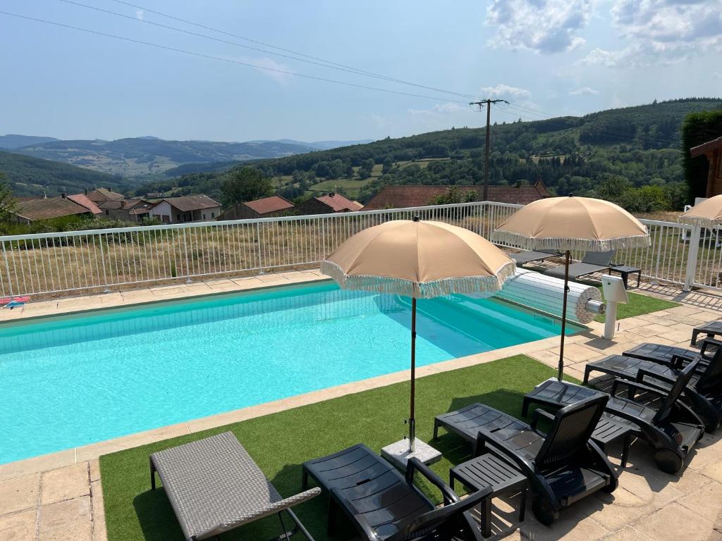 a swimming pool with chairs and umbrellas next to at Domaine-Bayard in Bergesserin