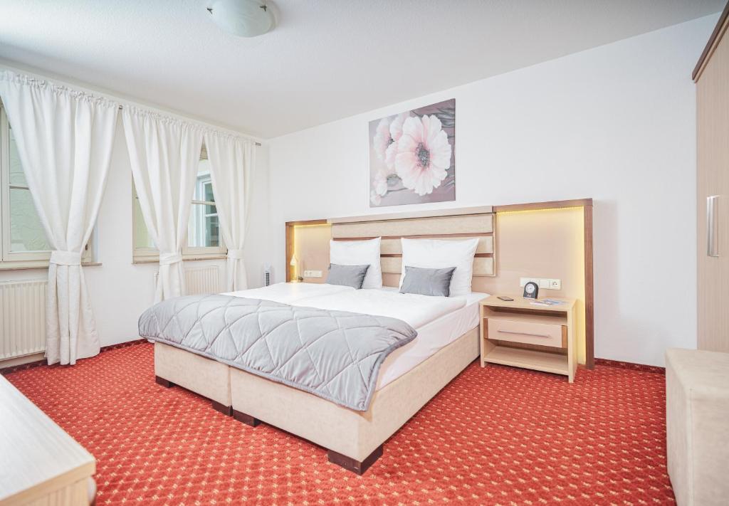 1 dormitorio con 1 cama grande y alfombra roja en Apart Business Hotel, en Stuttgart