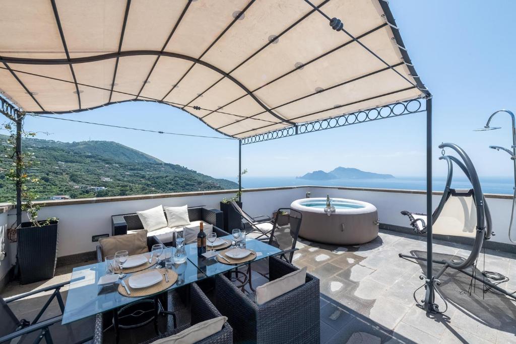 d'un balcon avec une baignoire et une table. dans l'établissement Torre del Saraceno, à Massa Lubrense