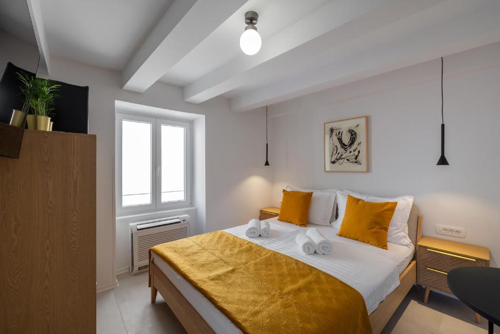 1 dormitorio con 1 cama grande con almohadas amarillas en B&B Miracolo di Mare Golden House, en Piran