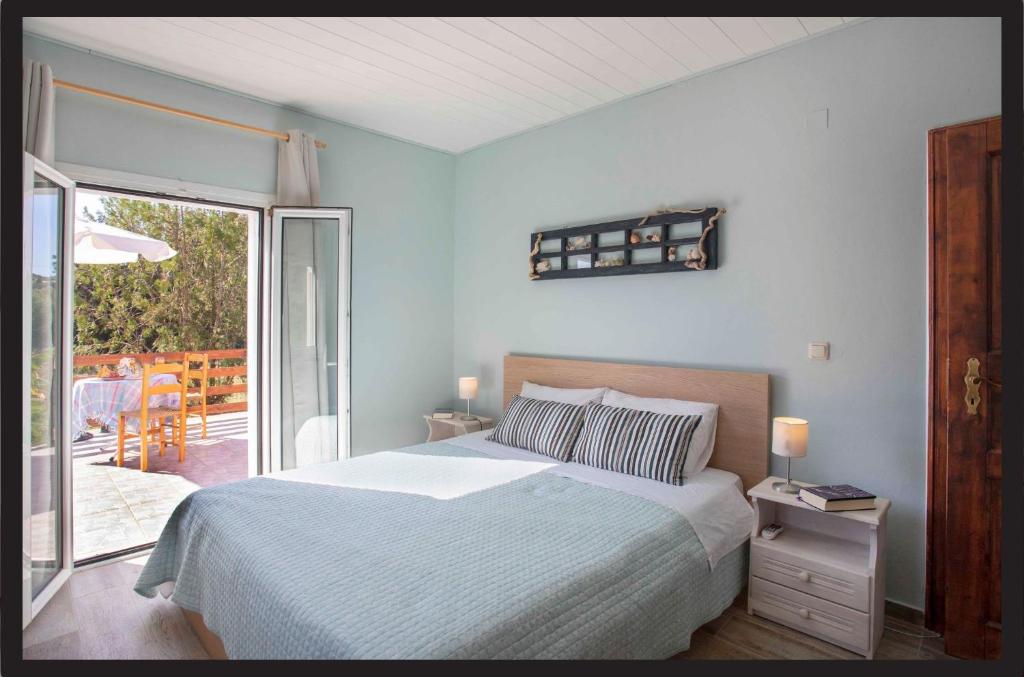 a blue bedroom with a bed and a balcony at Joleni Cottage in Keramies in Kefallonia