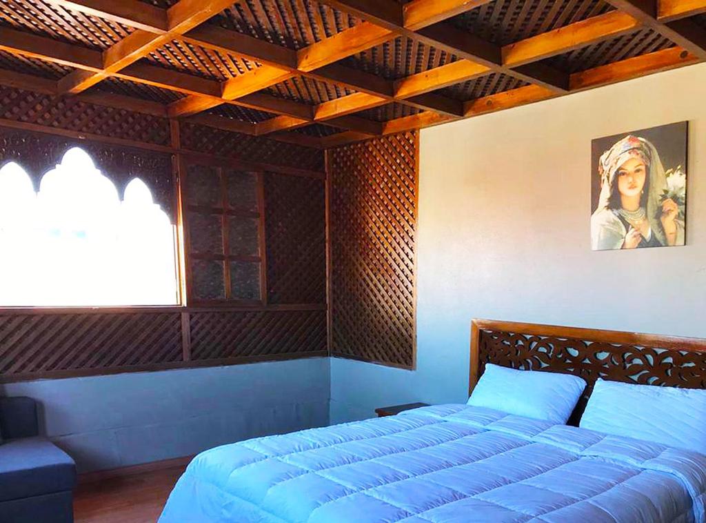 - une chambre avec un lit bleu et une fenêtre dans l'établissement Résidence la Paix, à Marrakech