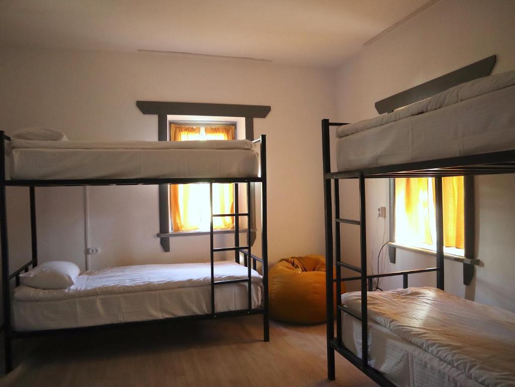 2 literas en una habitación con 2 ventanas en ESENIN 1 Hostel & Bar, en Karakol