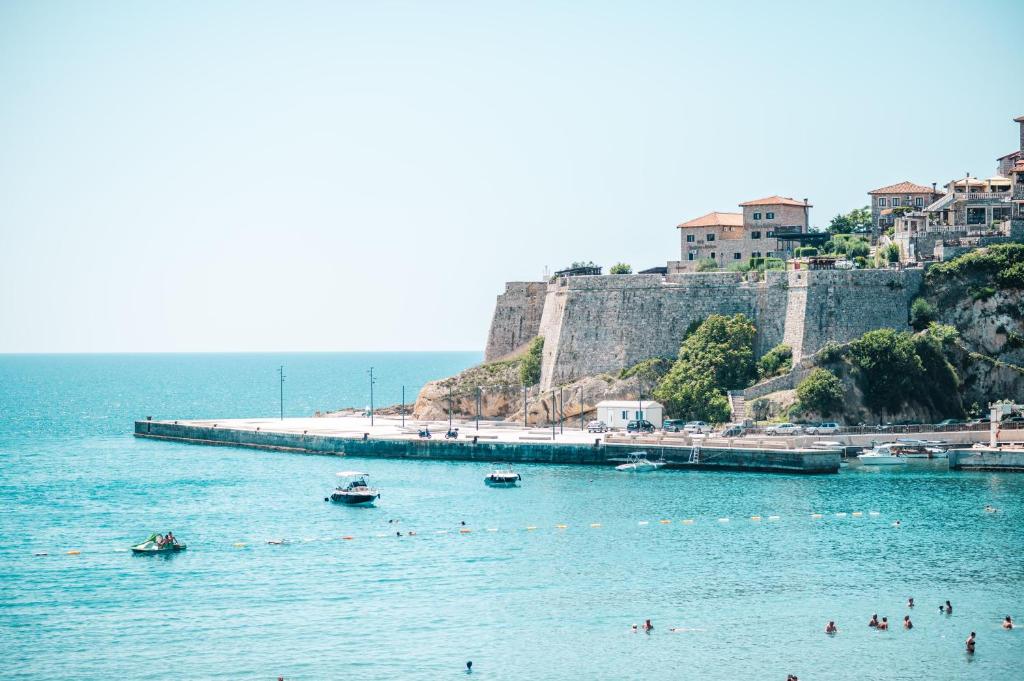 un grupo de personas en el agua en una playa en Miramar en Ulcinj