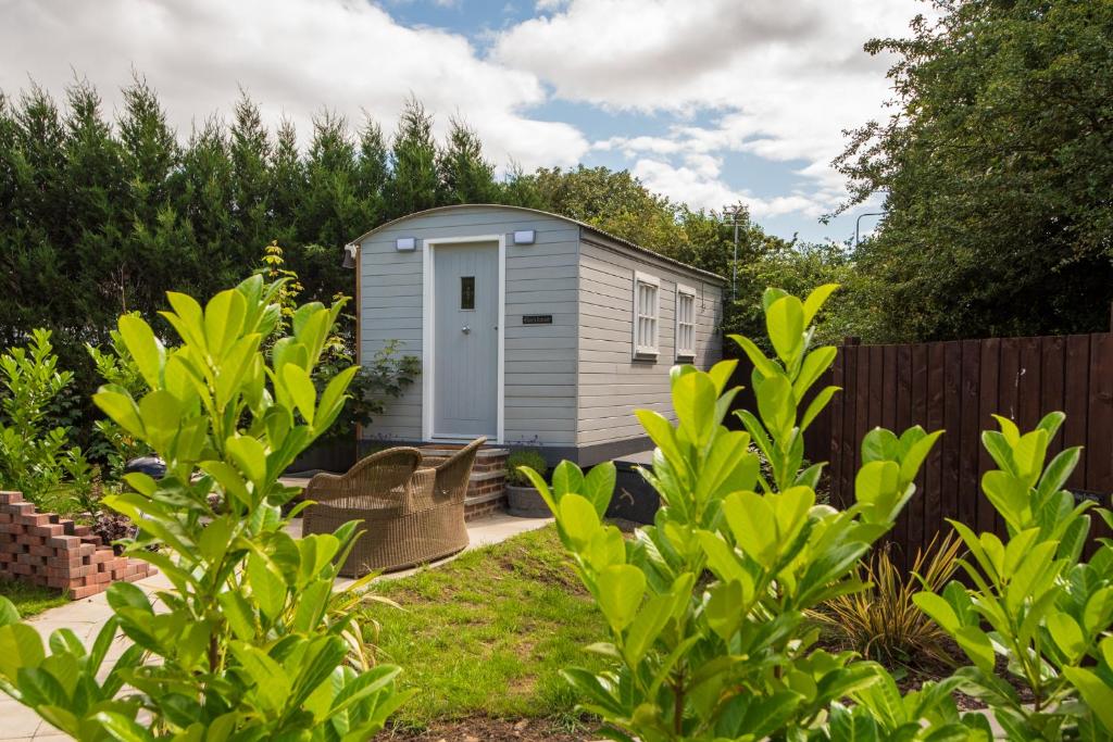 a small shed in a garden with a fence at Elsie's Retreat in Durham