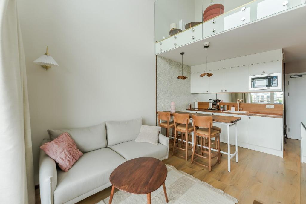 a living room with a couch and a table at Penthouse Lighthouse Mrzeżyno SurfingBird in Mrzeżyno