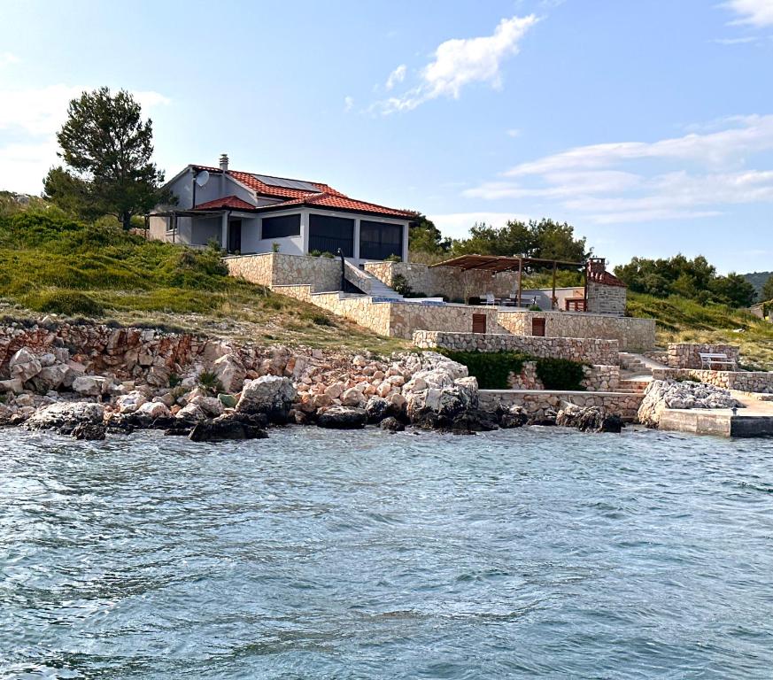 a house on a hill next to a body of water at La Isla in Tkon