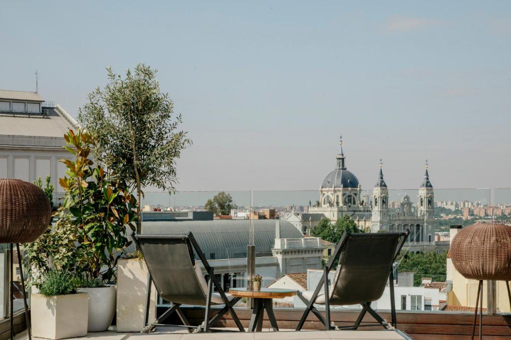 a table and chairs on the roof of a building at Palacio de los Duques Gran Meliá - The Leading Hotels of the World in Madrid