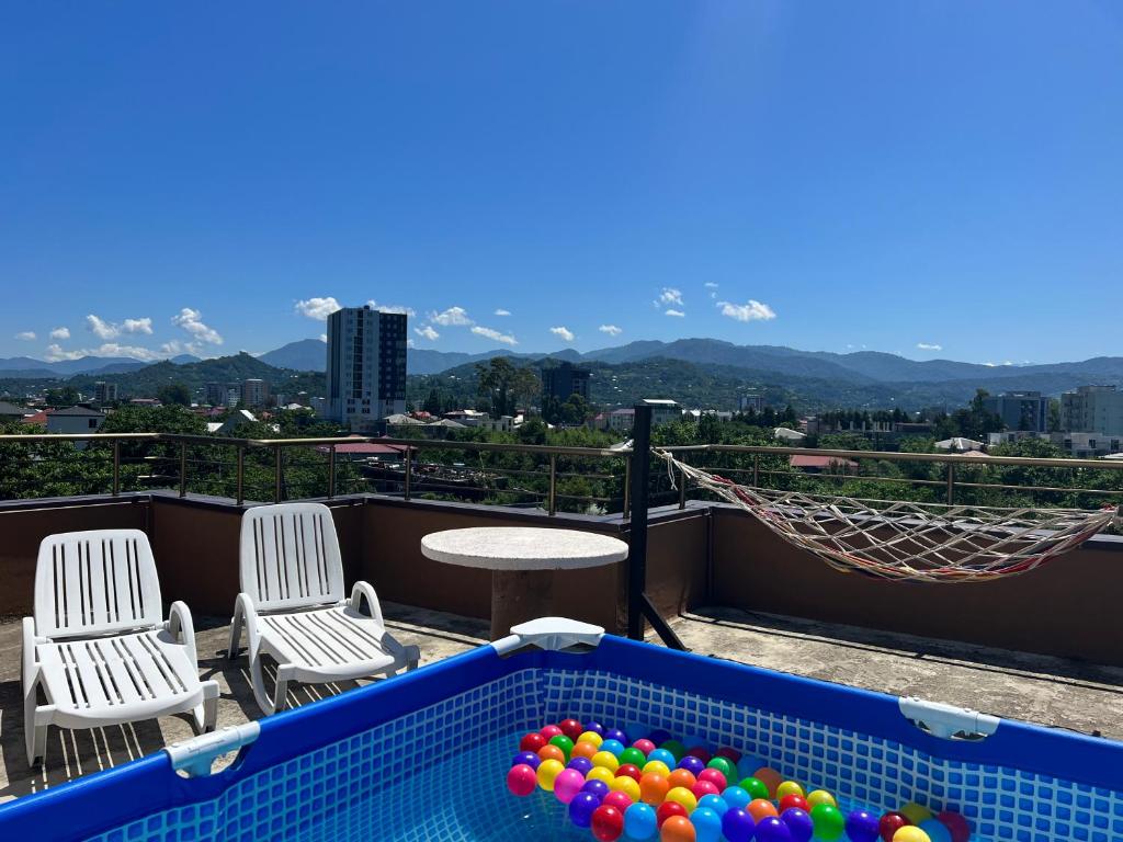 a swimming pool with chairs and balls on a balcony at Apartments NITA in Batumi