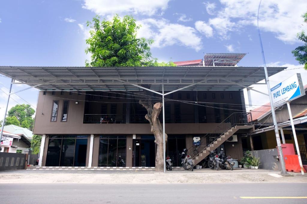 um edifício com uma árvore em frente em Hotel Puri Lembang near Universitas Sulawesi Barat Majene em Lutan