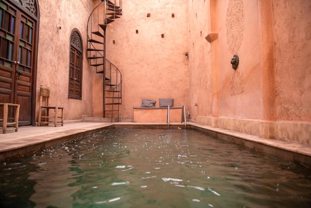 a pool of water in a building with stairs at Riad Ben Youssef in Marrakech