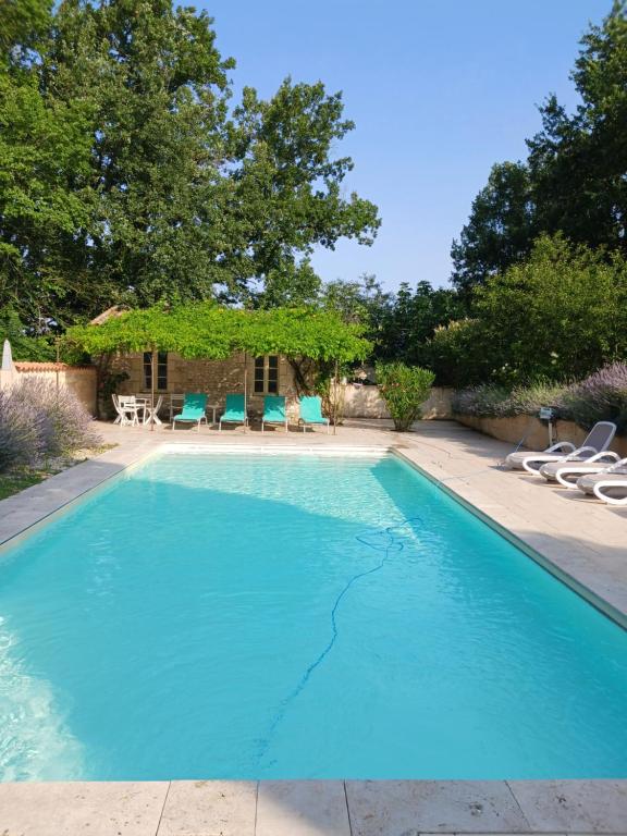 uma grande piscina azul com cadeiras num quintal em LA MAISON FORTE em Montaut