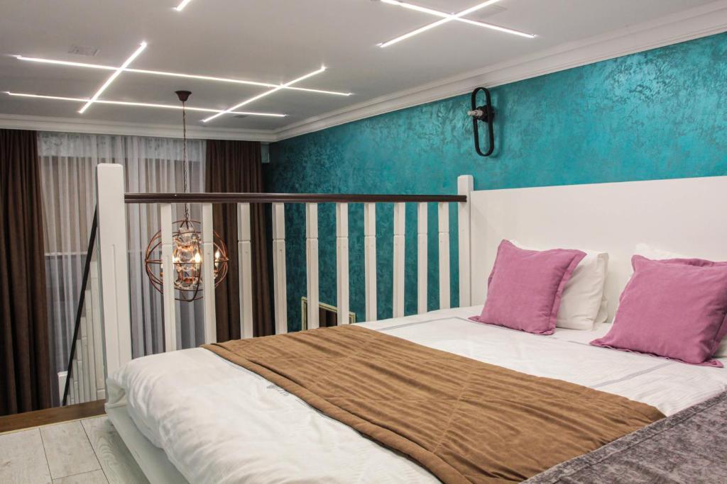 a bedroom with a large bed with purple pillows at E-lite& Meatador in Astana