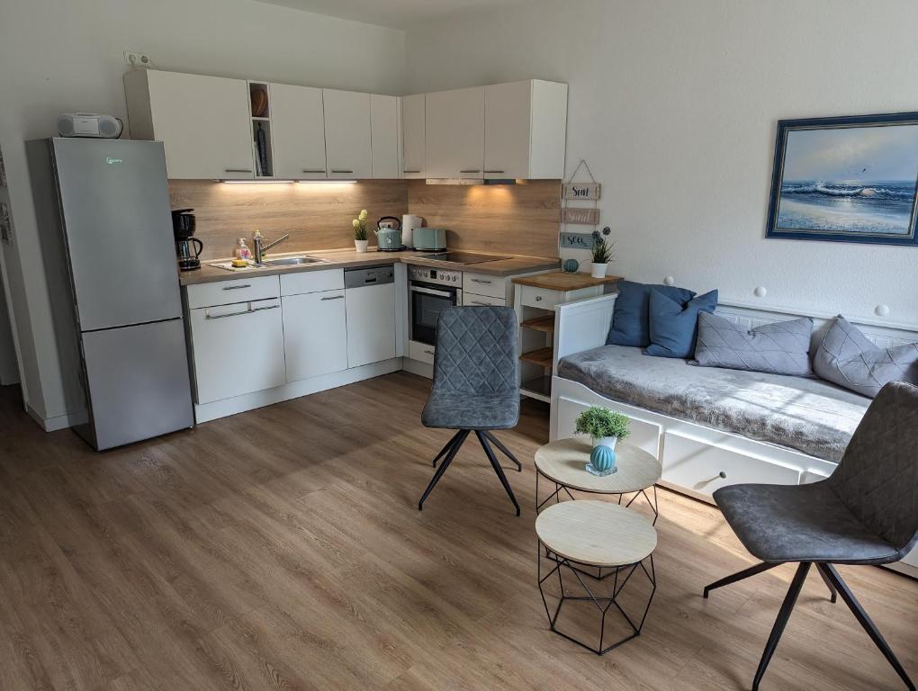 a kitchen and living room with a couch and a table at Fewo Freya in der Ostseeresidenz Gendarm in Wischuer