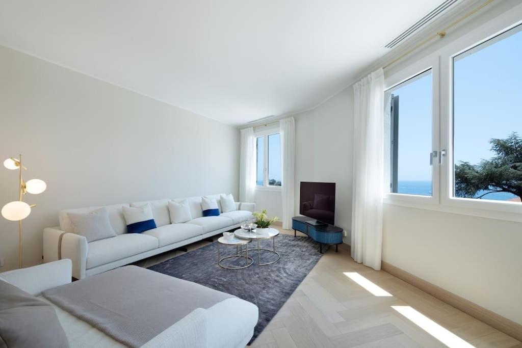 un salon avec un canapé blanc et une grande fenêtre dans l'établissement La Clubhouse, Monaco Country Club, à Roquebrune-Cap-Martin