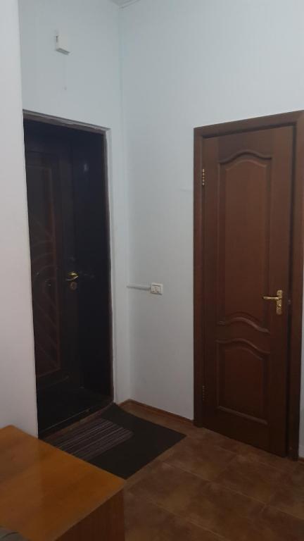 an empty room with two wooden doors and a rug at Колливинг на Республике (золотой квадрат) in Astana