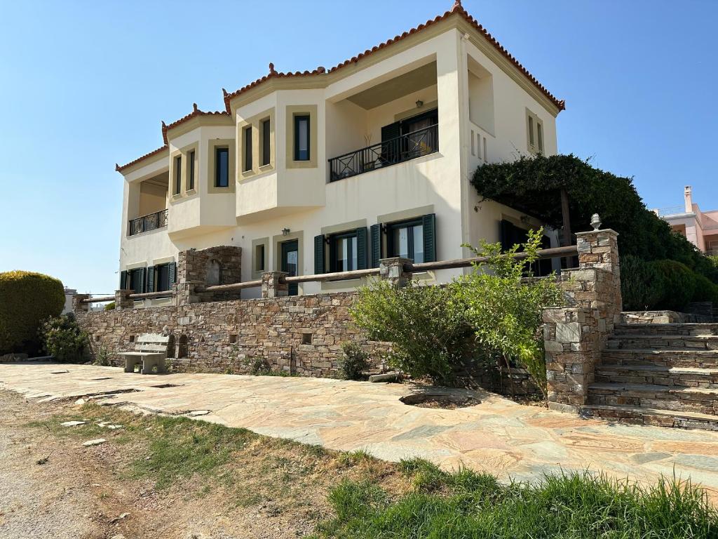 een groot wit huis op een stenen muur bij Belvedere Karystos in Karistos