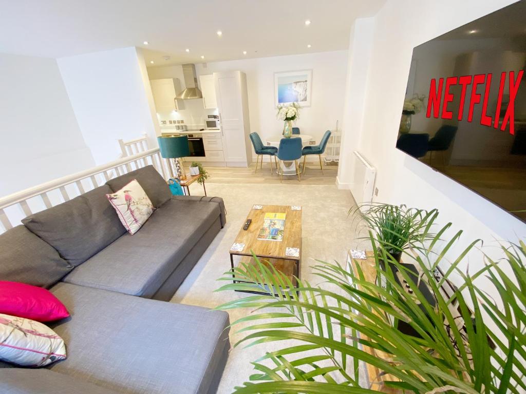 a living room with a couch and a table at The Seaside Maisonette. Free Parking/Close To Town in Bournemouth