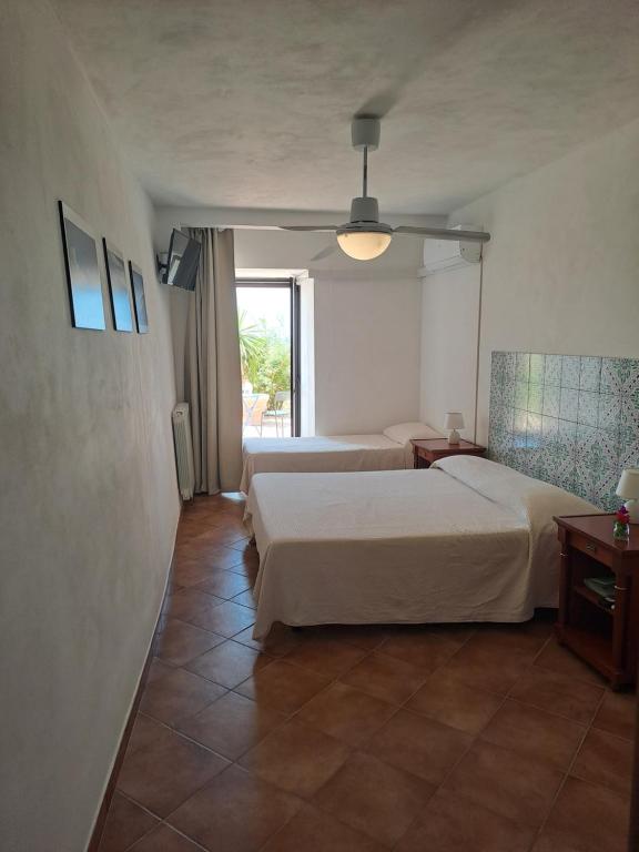 a hotel room with two beds and a window at Fattoria Manostalla Villa Chiarelli in Balestrate