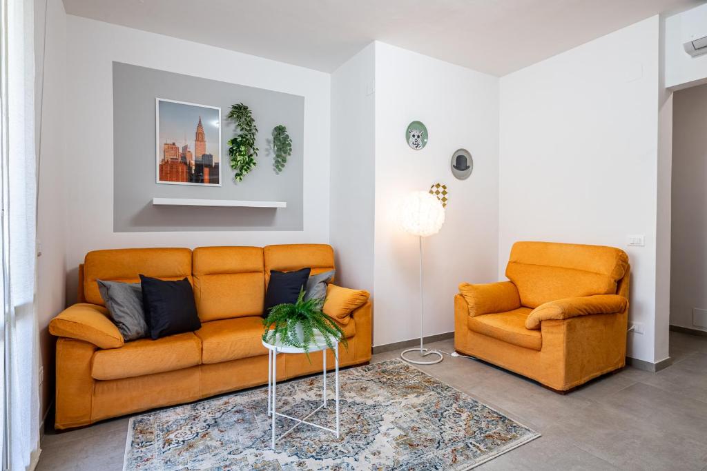 a living room with two orange couches and a table at Homiday - New House - Pisa Aeroporto - Free Parking in Pisa