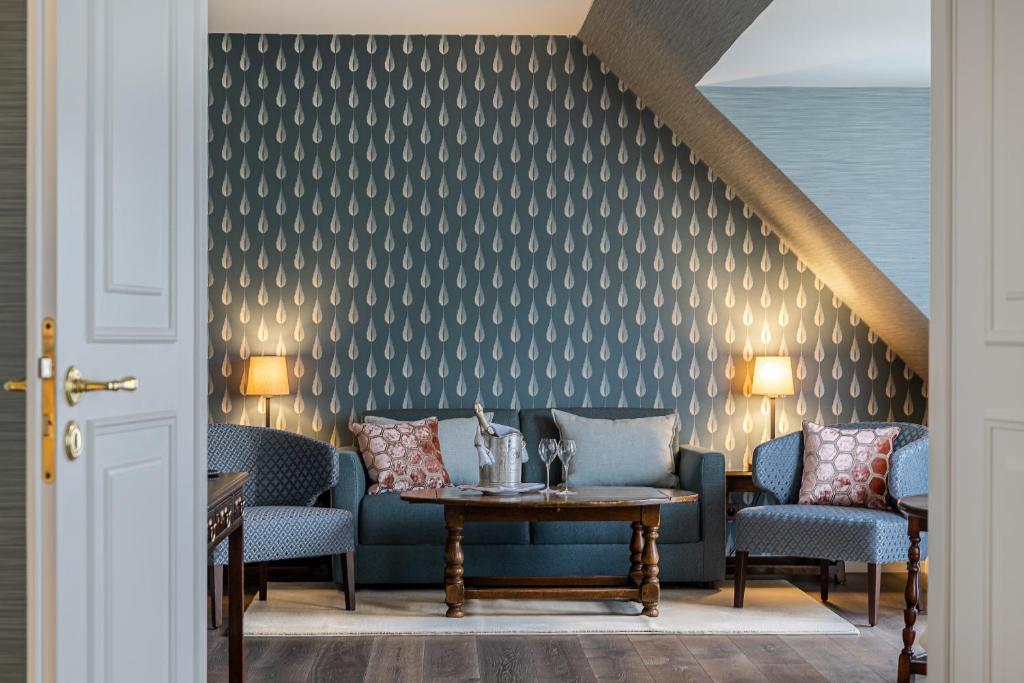 a room with a couch and chairs and a table at Hotel Stadt Hamburg in Westerland