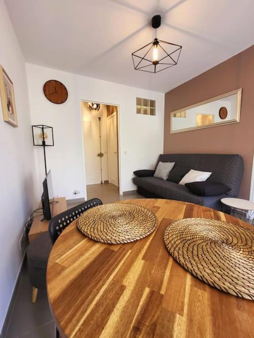 un salon avec une table en bois et un canapé dans l'établissement Cosy Studio à Cannes 8 min de la Croisette, à Cannes