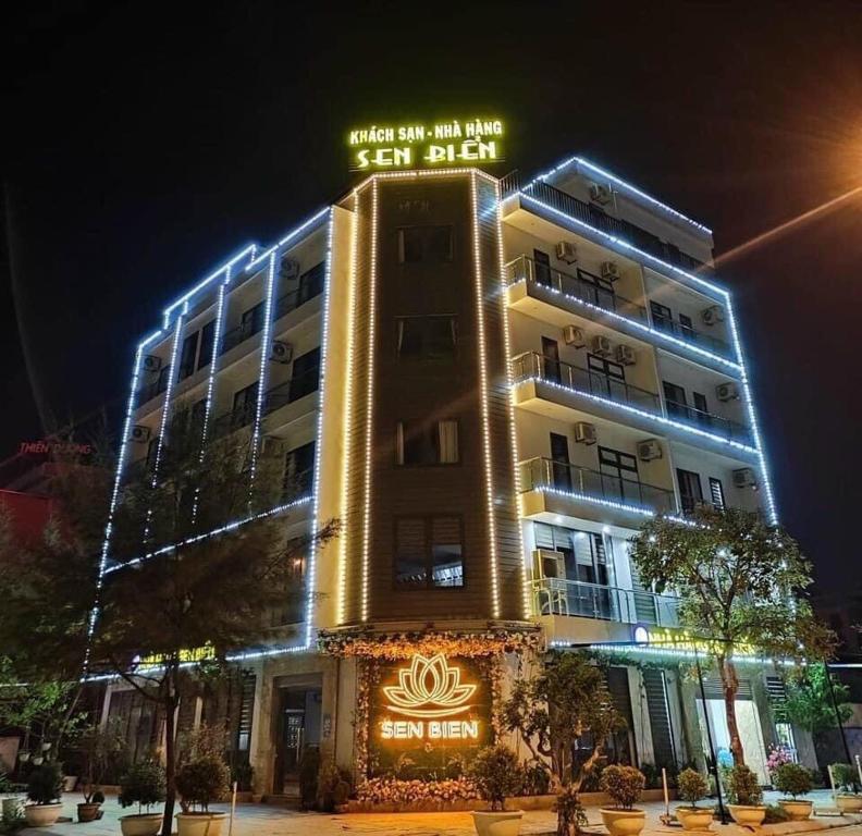 un bâtiment avec un panneau en haut de celui-ci la nuit dans l'établissement Sen Biển Hotel FLC Sầm Sơn, à Sầm Sơn