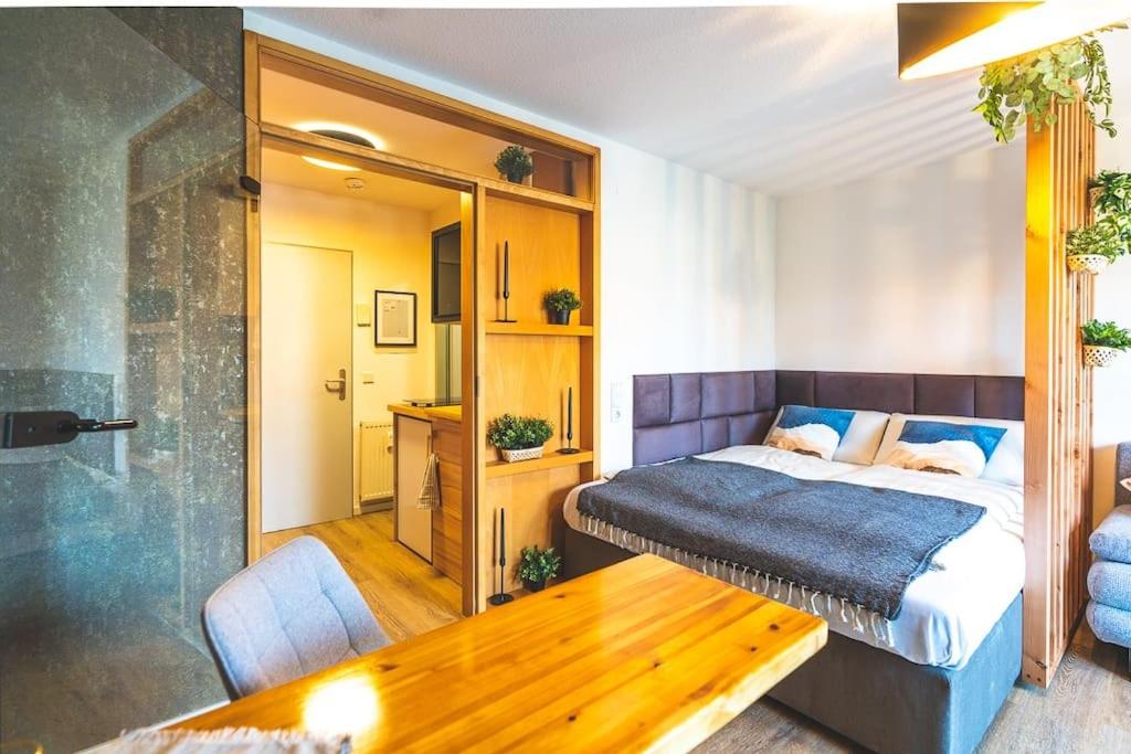 een slaapkamer met een bed en een houten tafel bij Golden Nugget (inkl. Netflix) in Detmold