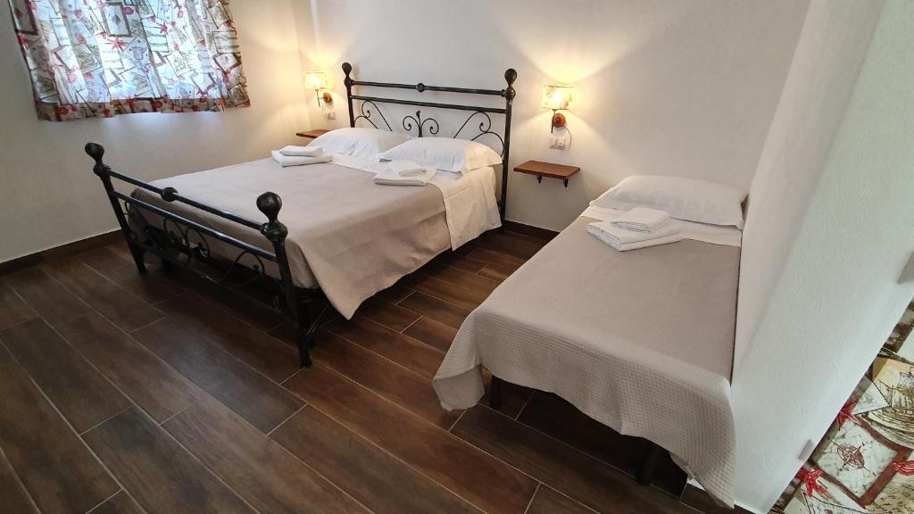 una camera con due letti con lenzuola bianche di DOMU NOSTA di Giulio & Ignazia Room2 a Santa Luria