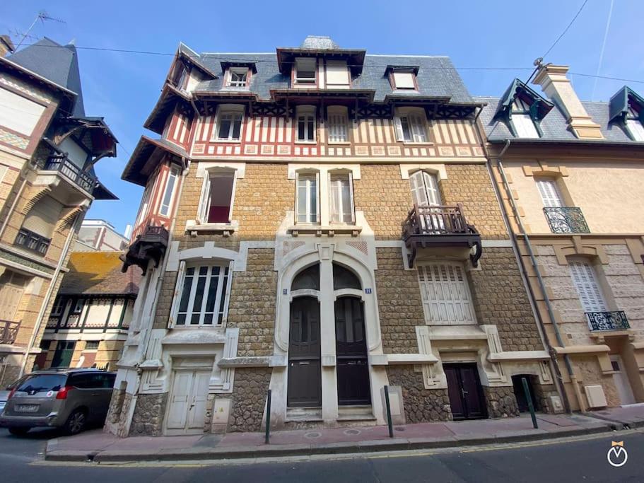 un grand bâtiment en briques au coin d'une rue dans l'établissement La Rose des Sables - Trouville sur Mer - 8P, à Trouville-sur-Mer