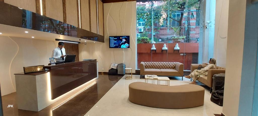 a man standing at a counter in a lobby at Lytton Hotel in Kolkata