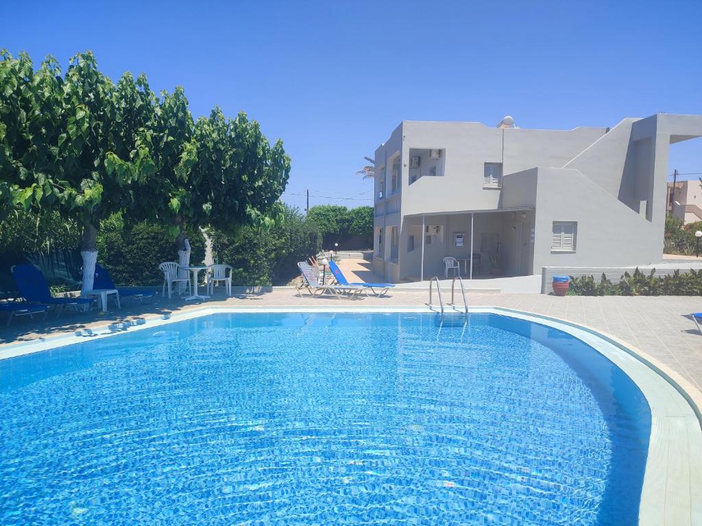 a large swimming pool in front of a building at Keti Apartments in Adelianos Kampos