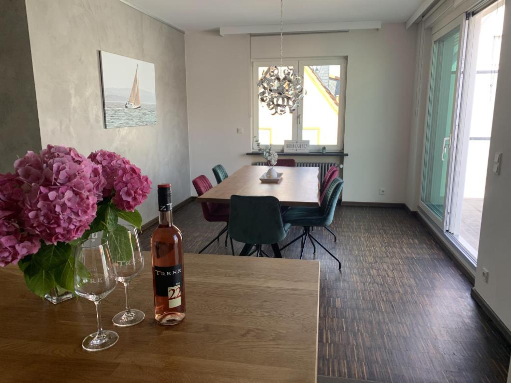 um quarto com uma mesa com uma garrafa de vinho e flores em Ferienwohnung Trenz em Geisenheim