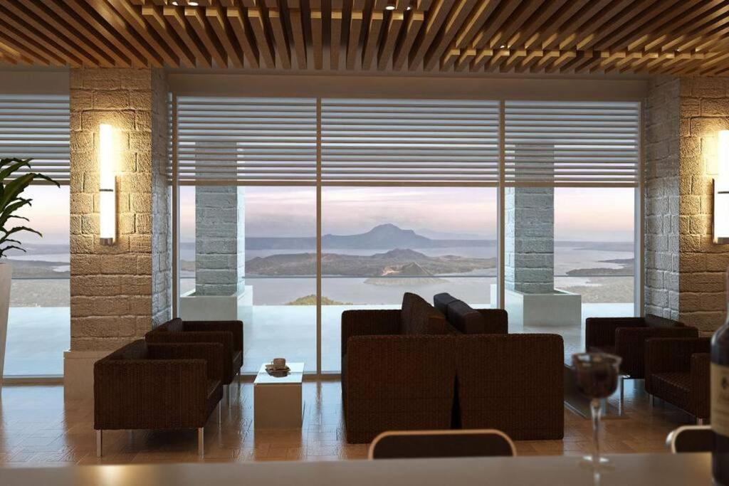 a living room with a large window with a view of the ocean at The Happy Home at Smdc Cool Suites Wind Residences in Tagaytay