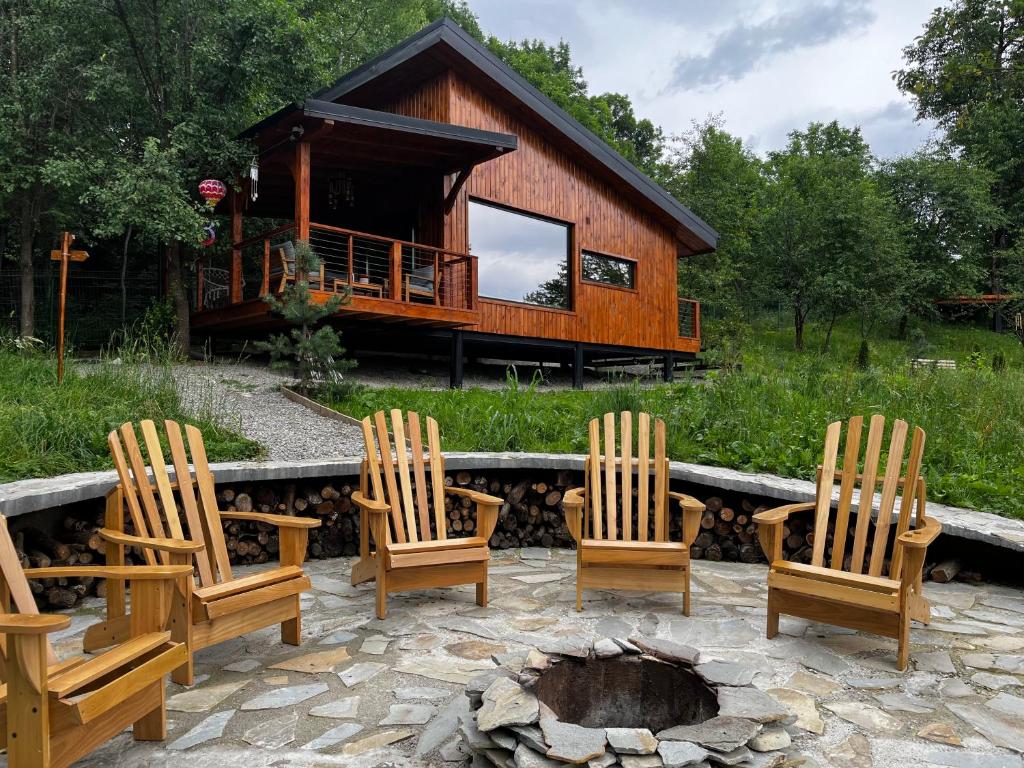 a group of chairs around a fire pit in front of a cabin at MoodySun Studio, remote tiny home in Comarnic