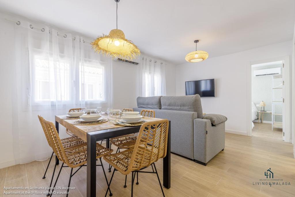 a dining room and living room with a table and chairs at Living4malaga Mi Carmela Beach in Málaga