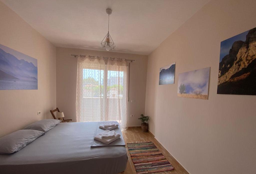 um quarto com uma cama e uma janela em MINO APARTMENT em Shkodër