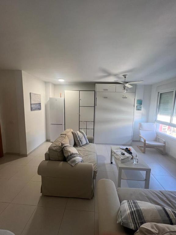 una sala de estar con un sofá y una mesa en ESTUDIO PLAYA LA BAJADILLA Roquetas de mar, en Roquetas de Mar