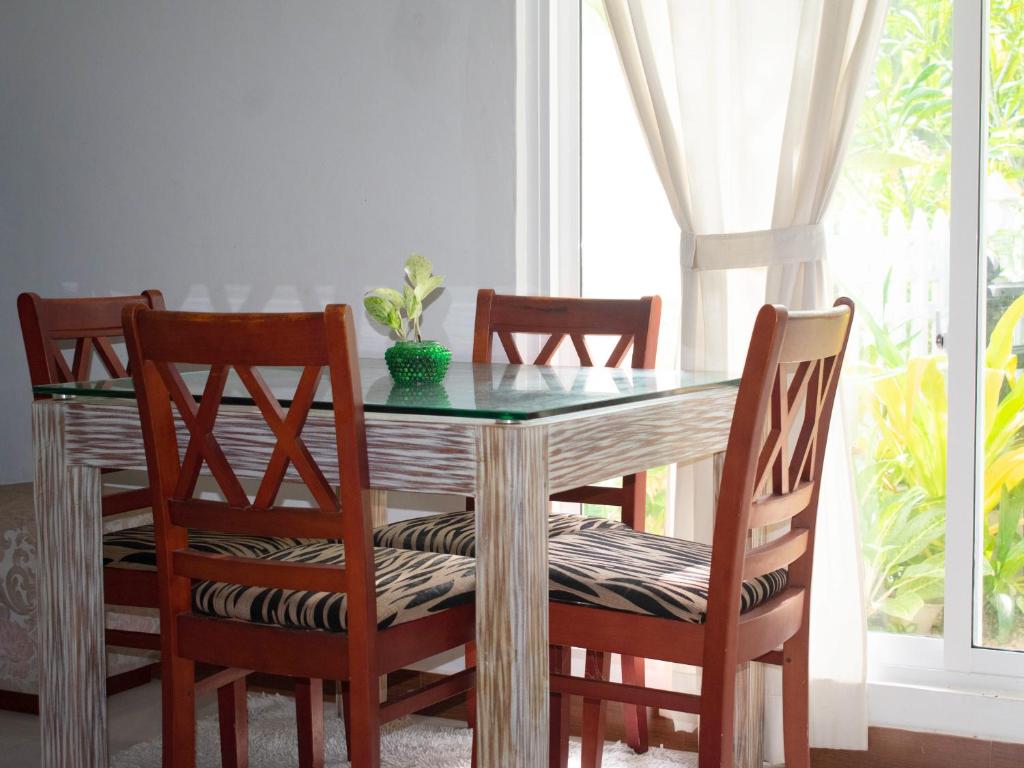 a dining room table with four chairs and a glass top at pvc 2 in Hikkaduwa