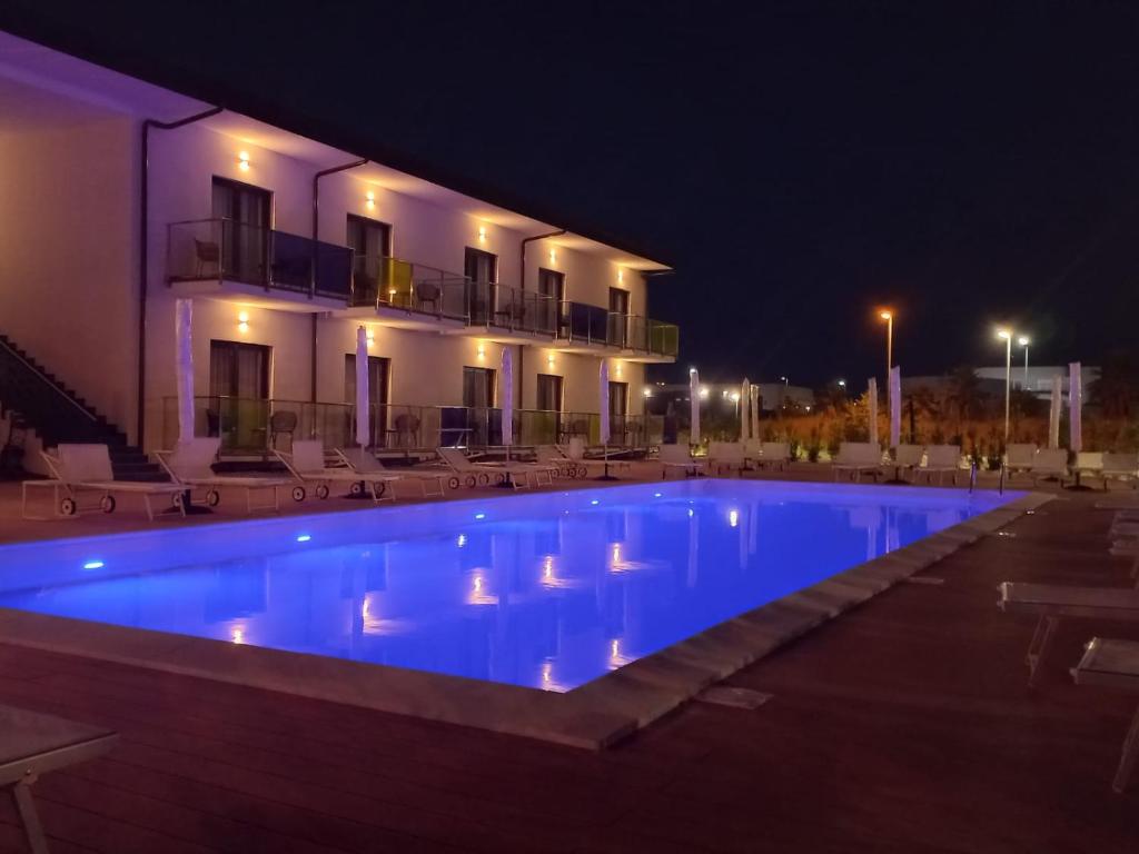 a swimming pool in front of a building at night at HOTEL MOSAICO in Matera
