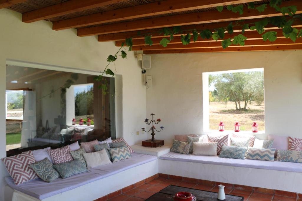 a living room with a couch and a large window at Monte da Casa Nova - Jul and Ago only 7 days stays check-in and check-out on Saturdays in Vale de Água